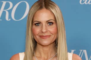 I don't know who this person is. A person with long blonde hair smiles for the camera against a blue background with partial text