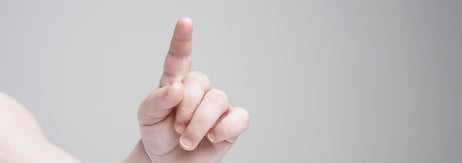 赤ちゃんが指を一本立てている手の写真。